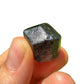 Grade a black tourmaline raw held in hand for size reference