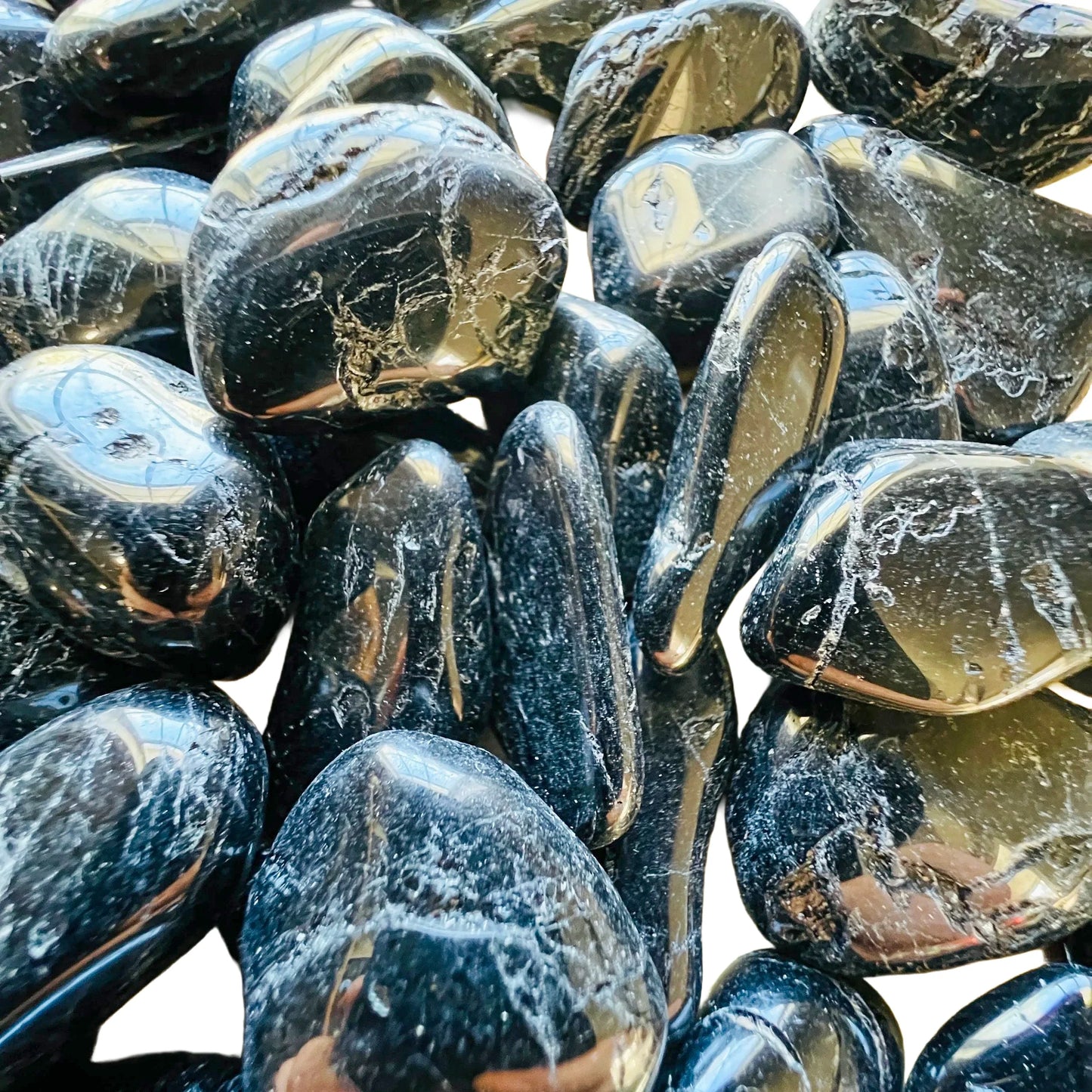 Reverse side of Grade AA Black Tourmaline tumbled stone, hand-selected from Minas Gerais, Brazil, often paired with practices.