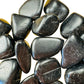 Reverse angle of Grade AA Black Tourmaline tumbled stone, showing earthy tone, linked to Protection and Grounding.