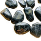 Studio-style view of Black Tourmaline tumbled stone, often kept for Cleansing, with weight visible in the palm.