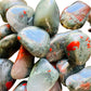 Top-side view of green Bloodstone tumbled stone, showing natural inclusions, often kept for Energy.
