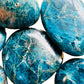 Scale reference of a Apatite palm stone held against natural backdrop, from Madagascar.