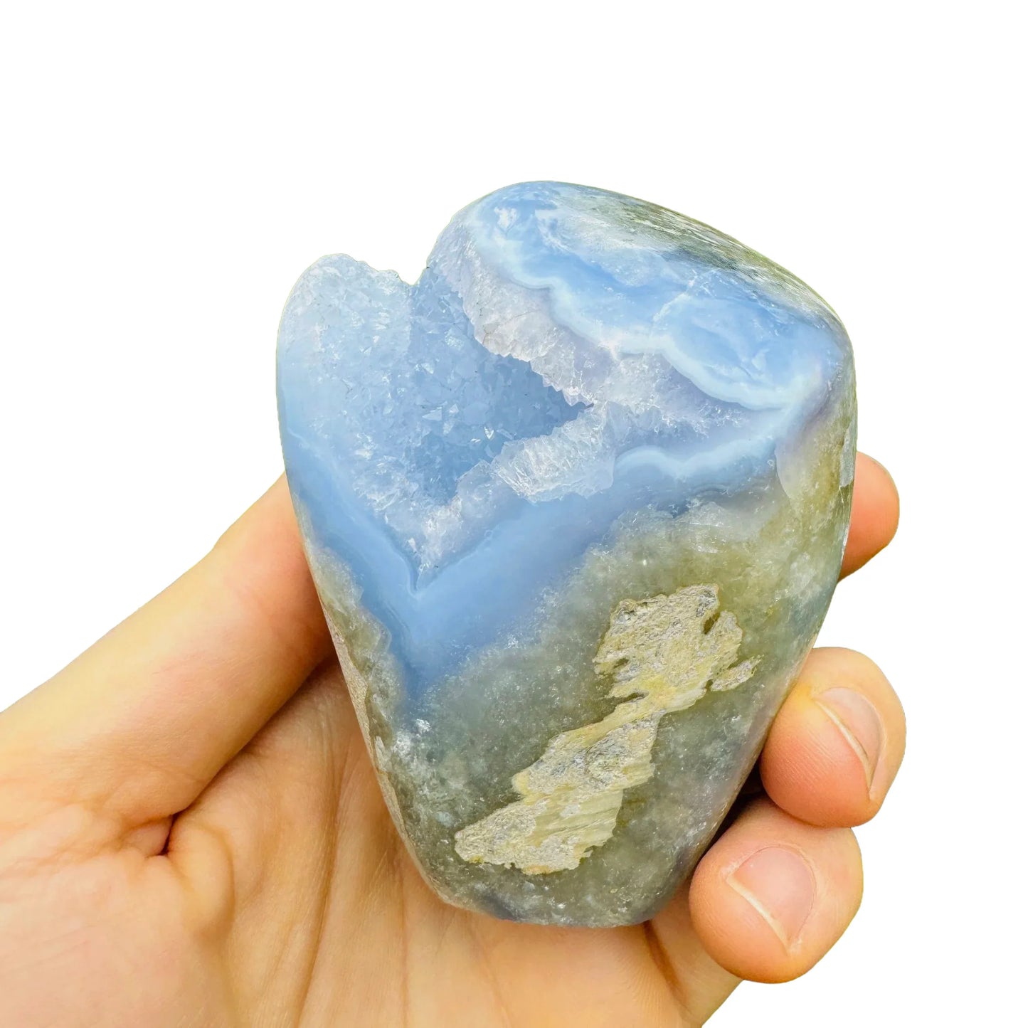 Hand-scale shot of a Blue Lace Agate specimen held against natural backdrop, Malawi-sourced.