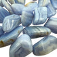 Sideways view of Blue Lace Agate tumbled stone, showing natural inclusions.