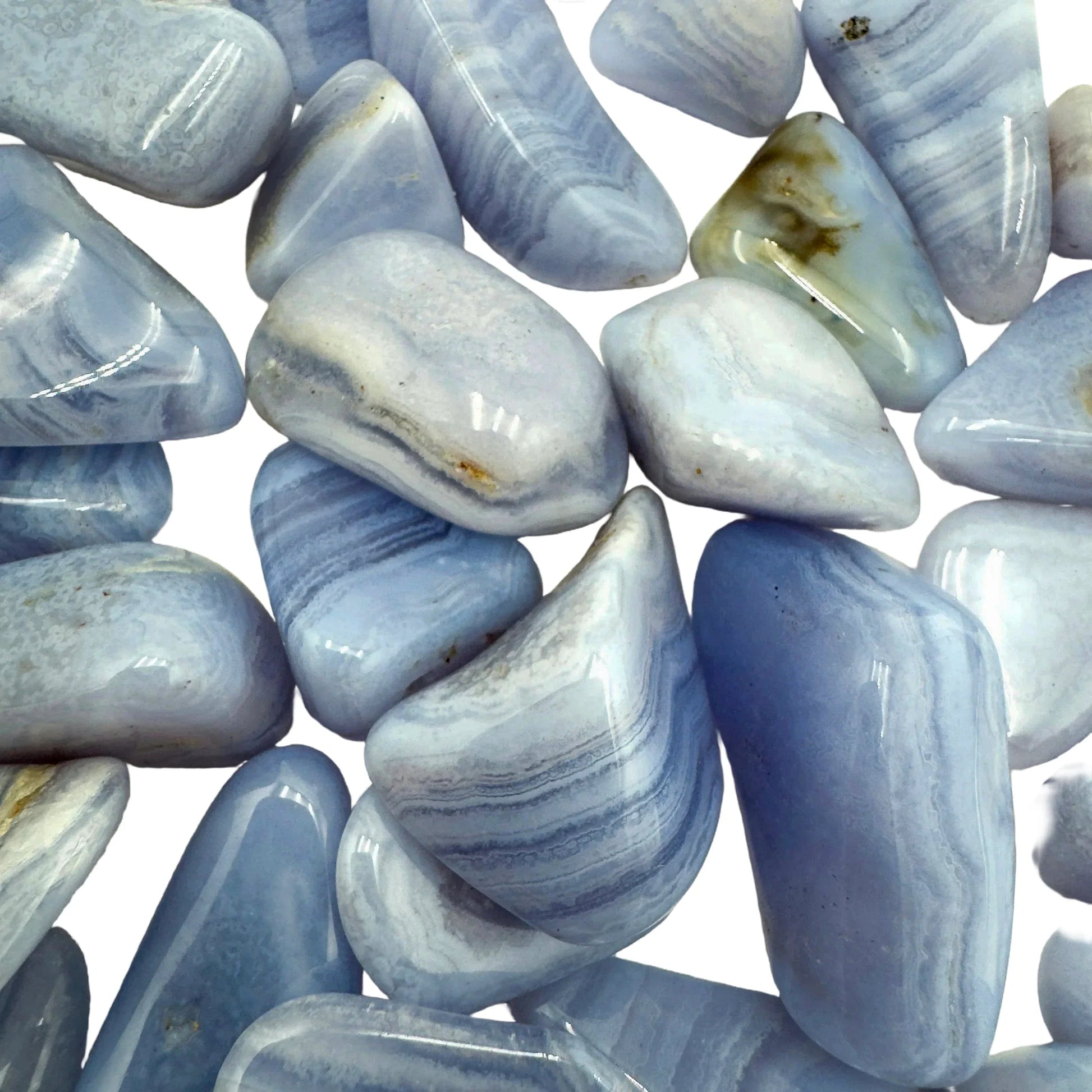 Hand-scale shot of a Blue Lace Agate tumbled stone held against natural backdrop.