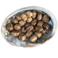Size comparison with a Brown Aragonite tumbled stone held against natural backdrop.
