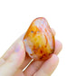 Quiet study of Carnelian palm stone, from Boeny, Madagascar, linked to Creativity, set to give a sense of weight.