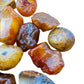 Hand-scale shot of a Carnelian raw stone, sourced from Brazil.