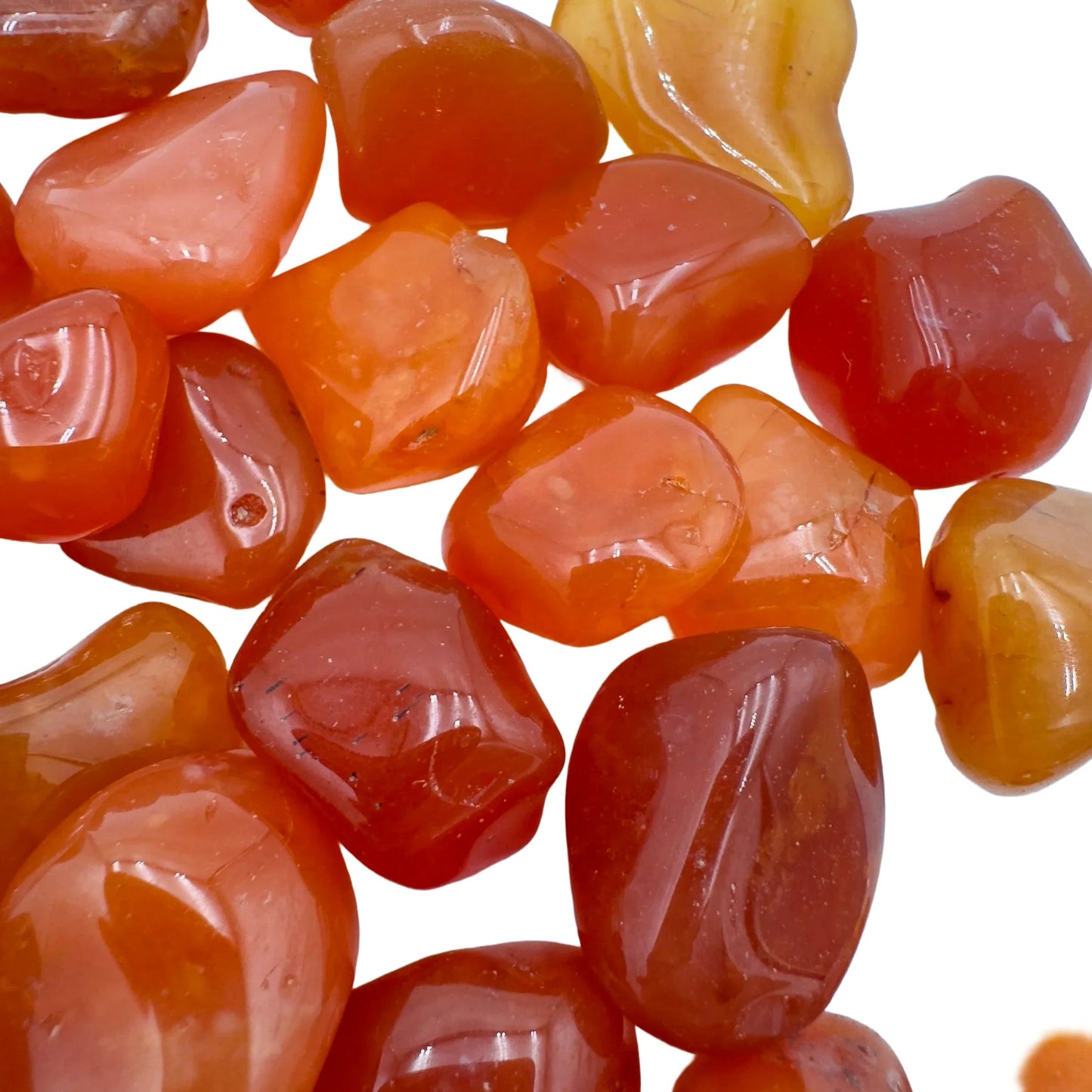 Lifestyle view of a Carnelian tumbled stone held against natural backdrop, hand-selected from Francistown, Botswana.