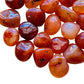 Texture-level view of Grade AA Carnelian tumbled stone, sourced from Paraná, Brazil, showing natural inclusions.