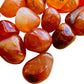 Lateral view of orange Carnelian tumbled stone, Brazil-sourced, showing natural variation.