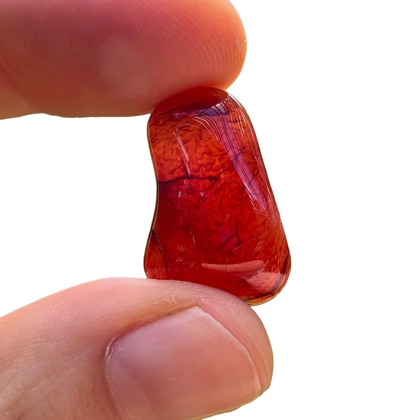 Overhead angle of Carnelian tumbled stone, showing translucent edges, hand-selected from Paraná, Brazil.