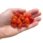 Detail shot of Grade AA Carnelian tumbled stone under natural light