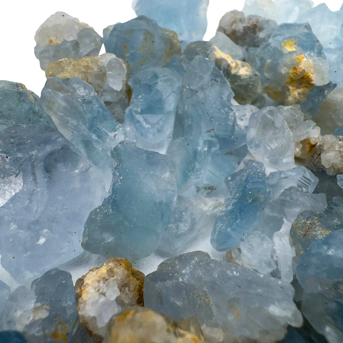 Held in palm of a Celestite raw crystal, from Sakoany, Madagascar, traditionally used for Stress Relief, with depth visible across the surface.