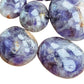Side profile of Chevron Amethyst palm stone, showing earthy tone, associated with Intuition.