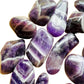 Lateral view of Grade AA Chevron Amethyst tumbled stone, showing characteristic patterning.