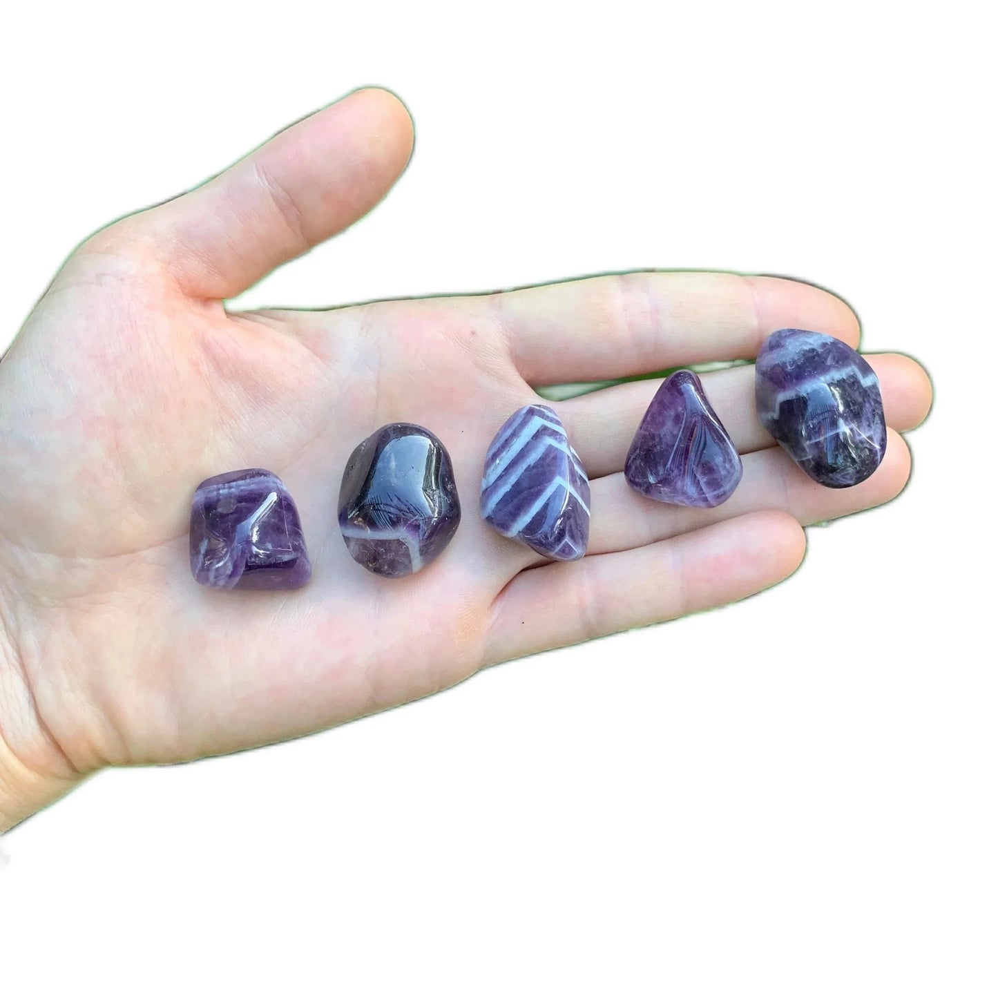Palm-scale view of a Chevron Amethyst tumbled stone, Zambia-sourced, sourced from Zambia.