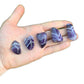 Composed shot of Chevron Amethyst tumbled stone, shown at hand scale.