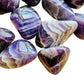 Overhead angle of purple Chevron Amethyst tumbled stone, showing soft luster, worked with for Intuition.
