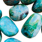 Held in hand, a single Chrysocolla tumbled stone sourced from Arequipa, Peru.