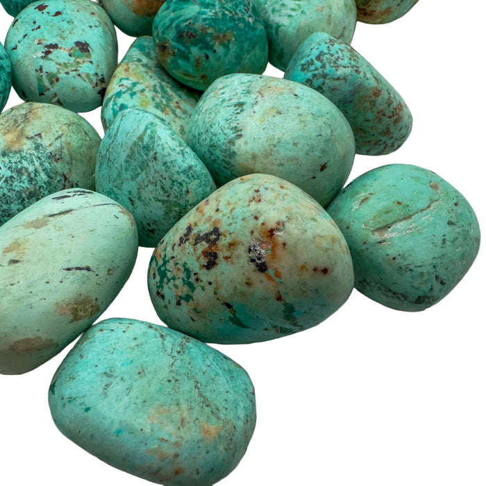 Edge-on view of Chrysocolla tumbled stone, showing subtle veining.