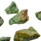 On a soft surface rests a Chrysoprase raw crystal, captured against a quiet backdrop.