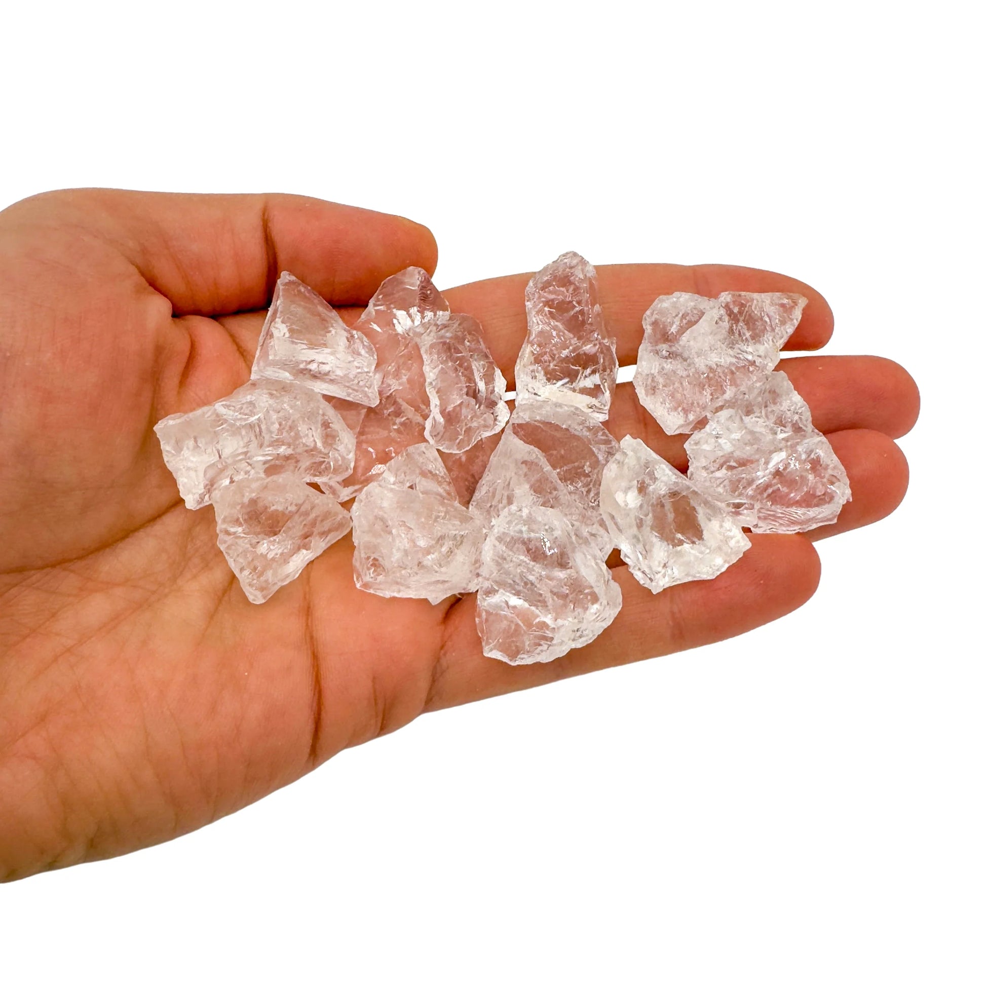 Hand holding small clear quartz raw crystals 5-10 grams Brazil scale reference