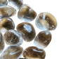 Palm-scale view of one Clear Quartz tumbled stone for scale, hand-selected from Minas Gerais, Brazil.