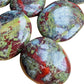 Overhead view of Dragon Bloodstone palm stone, hand-selected from Limpopo, South Africa, linked to Confidence.