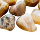 Side-on view of Grade AA Earth Moonstone tumbled stone, showing translucent edges.
