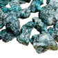 Daylight view of a Emerald raw stone held against natural backdrop.
