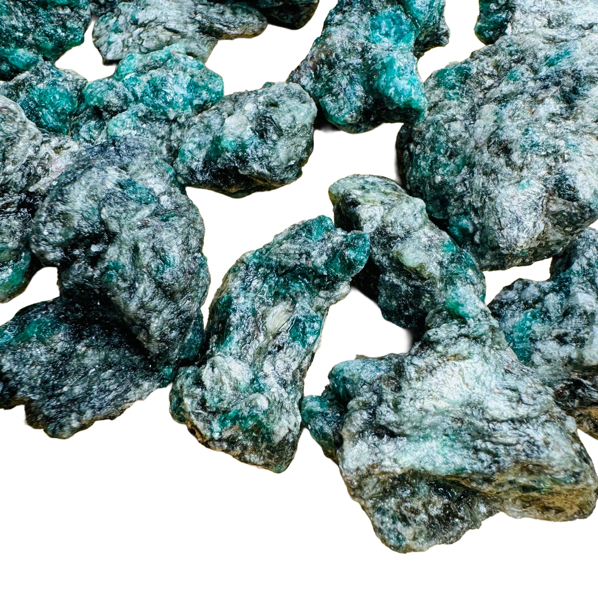 Daylight view of a Emerald raw stone held against natural backdrop.