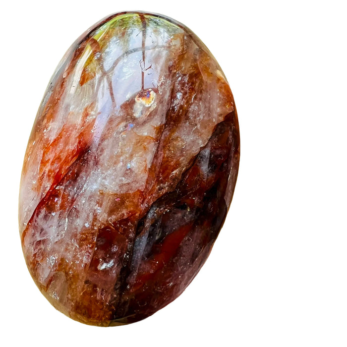 Near view of red Fire Quartz palm stone, showing soft luster.
