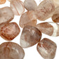 Bird's-eye view of red Fire Quartz tumbled stone, showing soft luster, Madagascar-sourced.