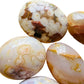 Overhead view of Flower Agate palm stone, drawn on for Love, showing natural inclusions.