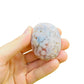 Hand-scale shot of a Flower Agate palm stone, sourced from Madagascar.