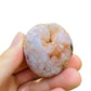 Hand-scale view of Flower Agate palm stone, from Boeny, Madagascar, shown at hand scale.