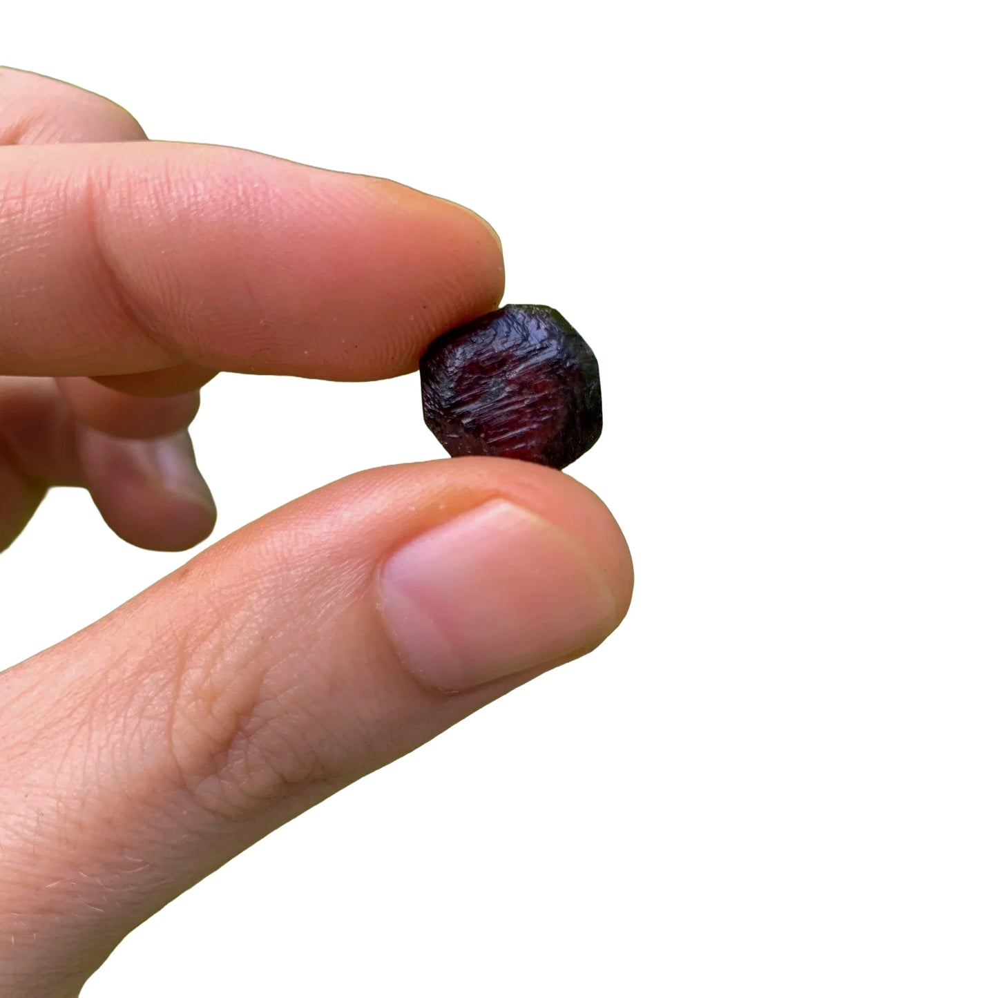 Three-quarter view of Garnet raw crystal, from Minas Gerais, Brazil, often kept for Grounding, with weight visible in the palm.