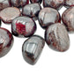 Sideways view of Garnet tumbled stone, showing soft luster, Malawi-sourced.