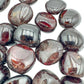 Quiet study of Garnet tumbled stone, from Nsipe, Malawi, captured against a quiet backdrop.