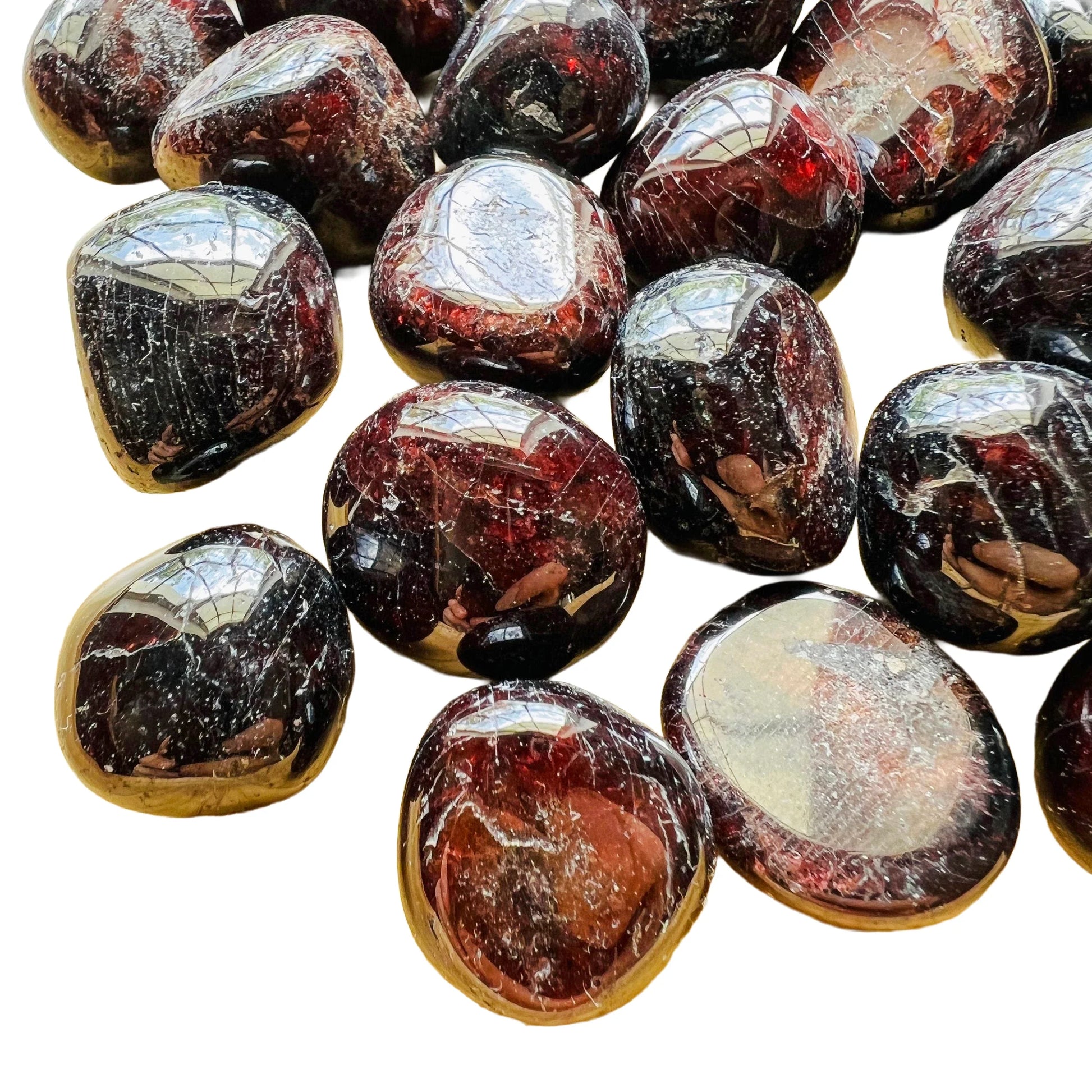 Near view of Grade AAA Garnet tumbled stone, linked to Energy.