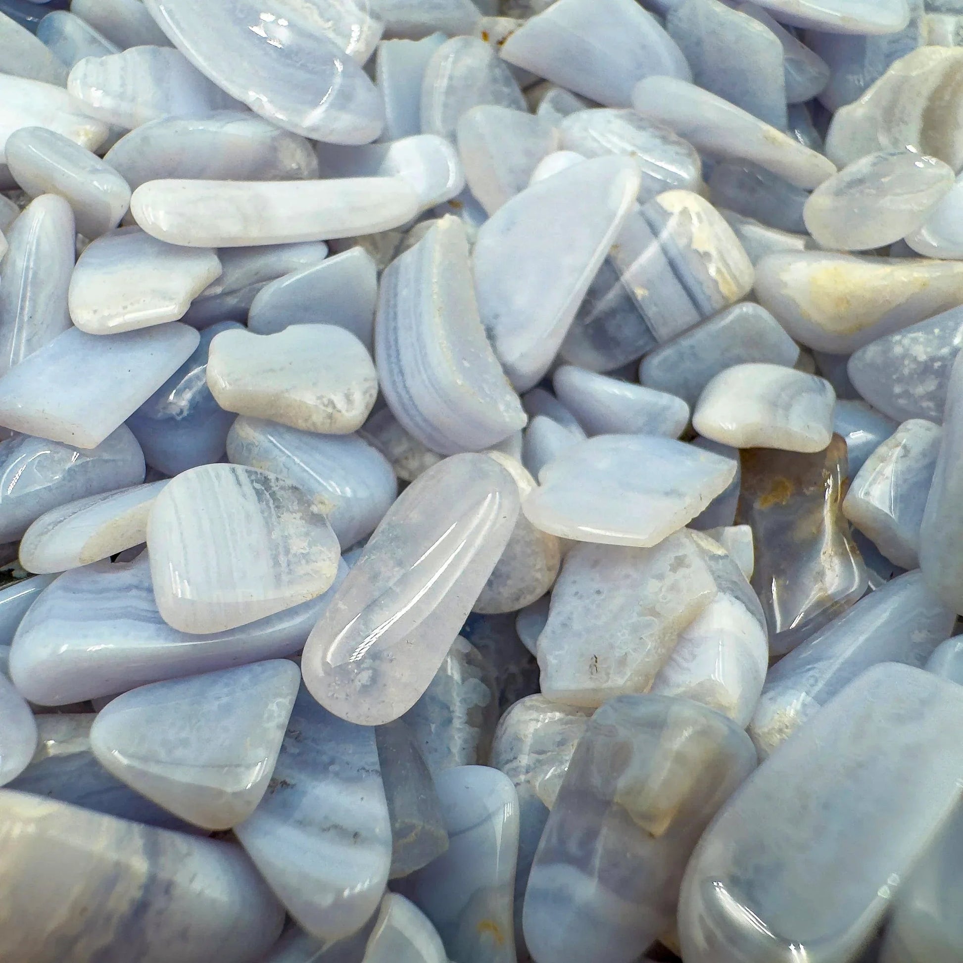 Top-down shot of Grade A Blue Lace Agate polished chip, often paired with practices around Stress Relief and Emotional Healing.