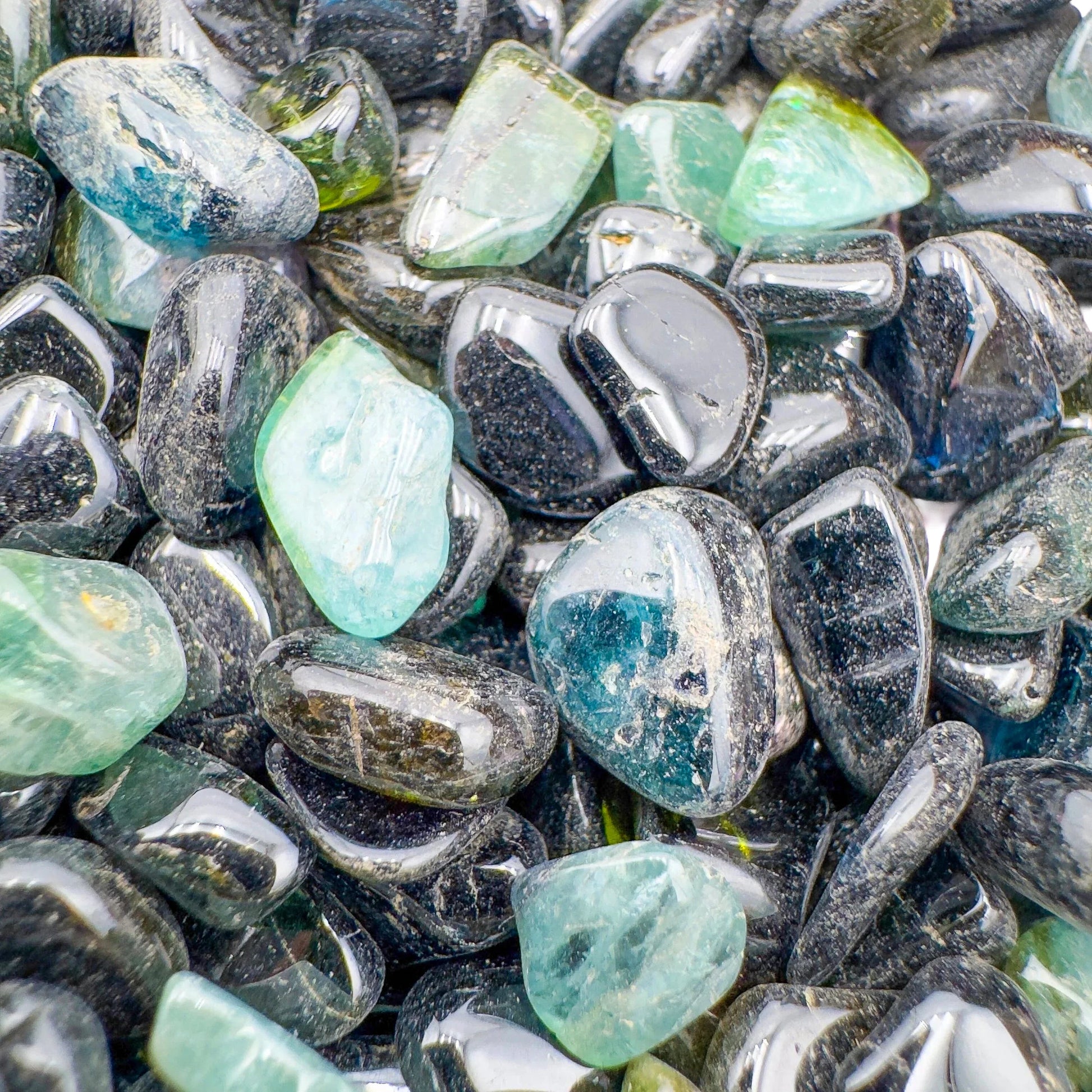 Sideways view of Green Tourmaline polished chip, showing natural sheen, sourced from Nampula, Mozambique.