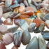 Pink agate polished chips in hand showing size reference, 0.25 to 0.50 inch pieces