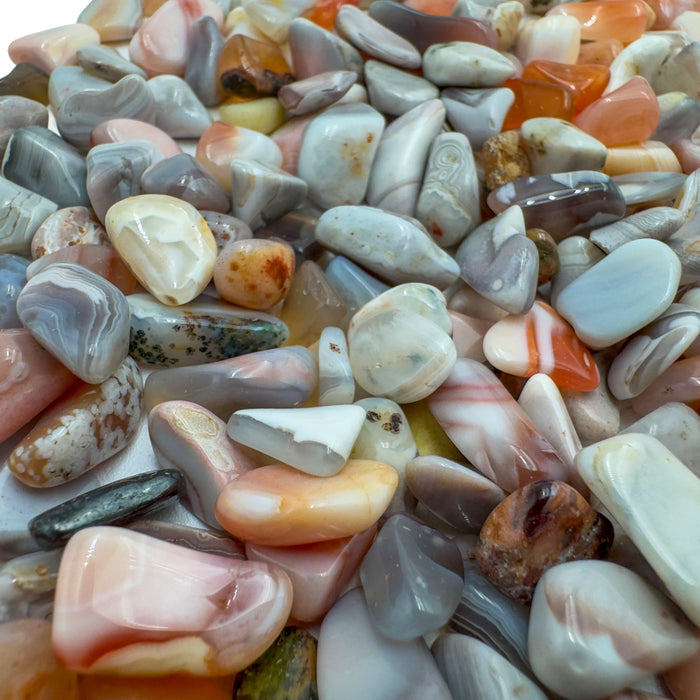 Pink agate crystal chips scattered on surface, Botswana chalcedony