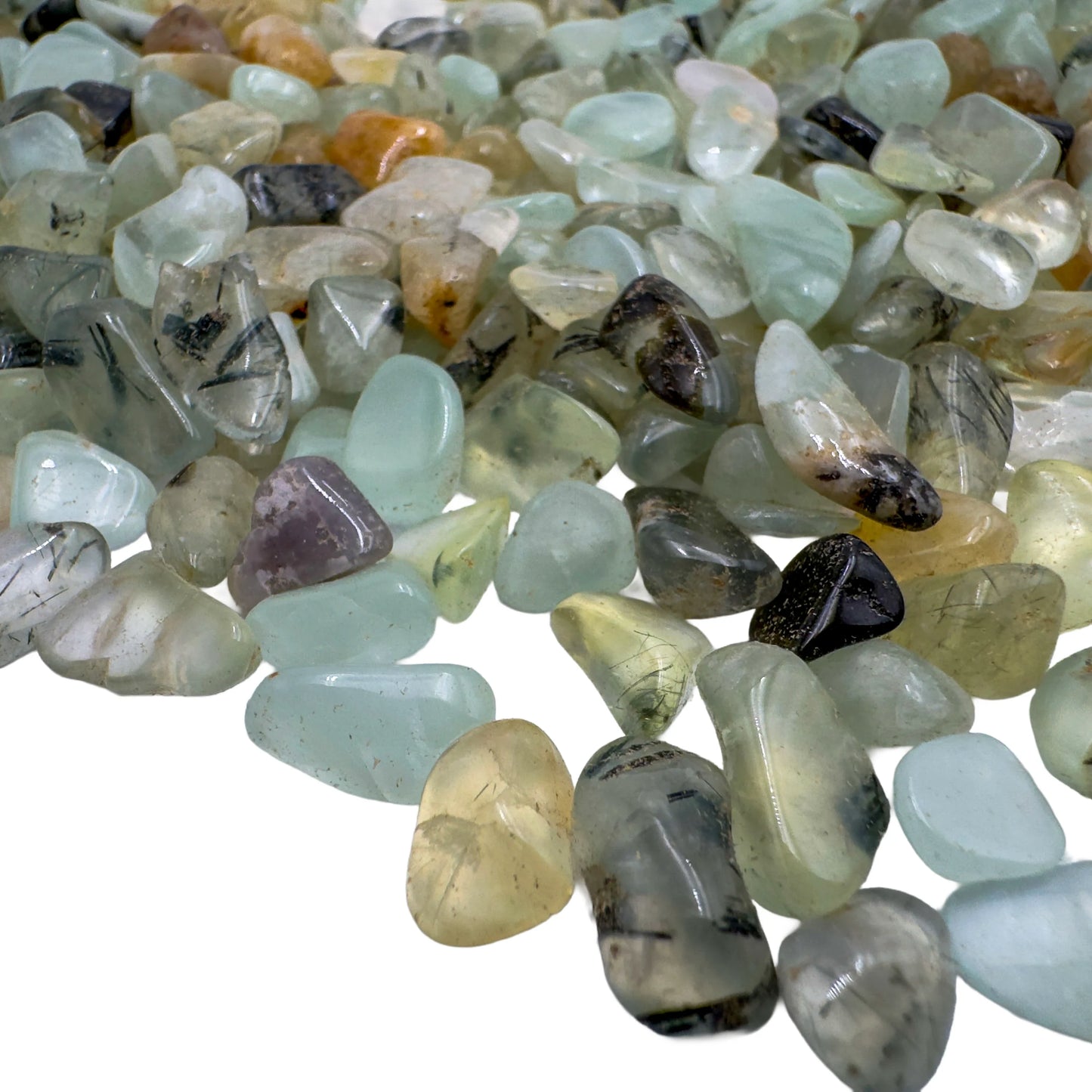 Prehnite polished chips in hand showing size reference, pale green Namibia material