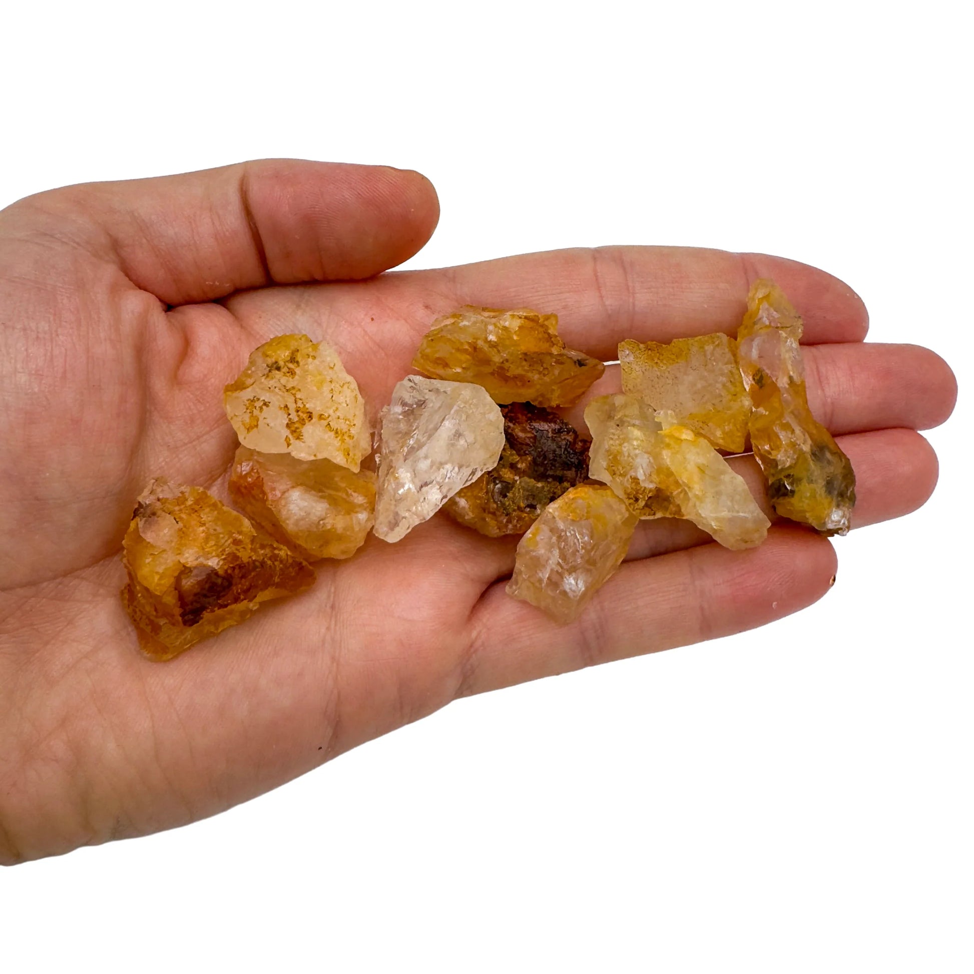 Hand holding small Golden Healer Quartz raw crystals 5-10 grams Brazil scale reference