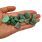 Hand holding small green aventurine raw stones 5-10 grams Brazil scale reference