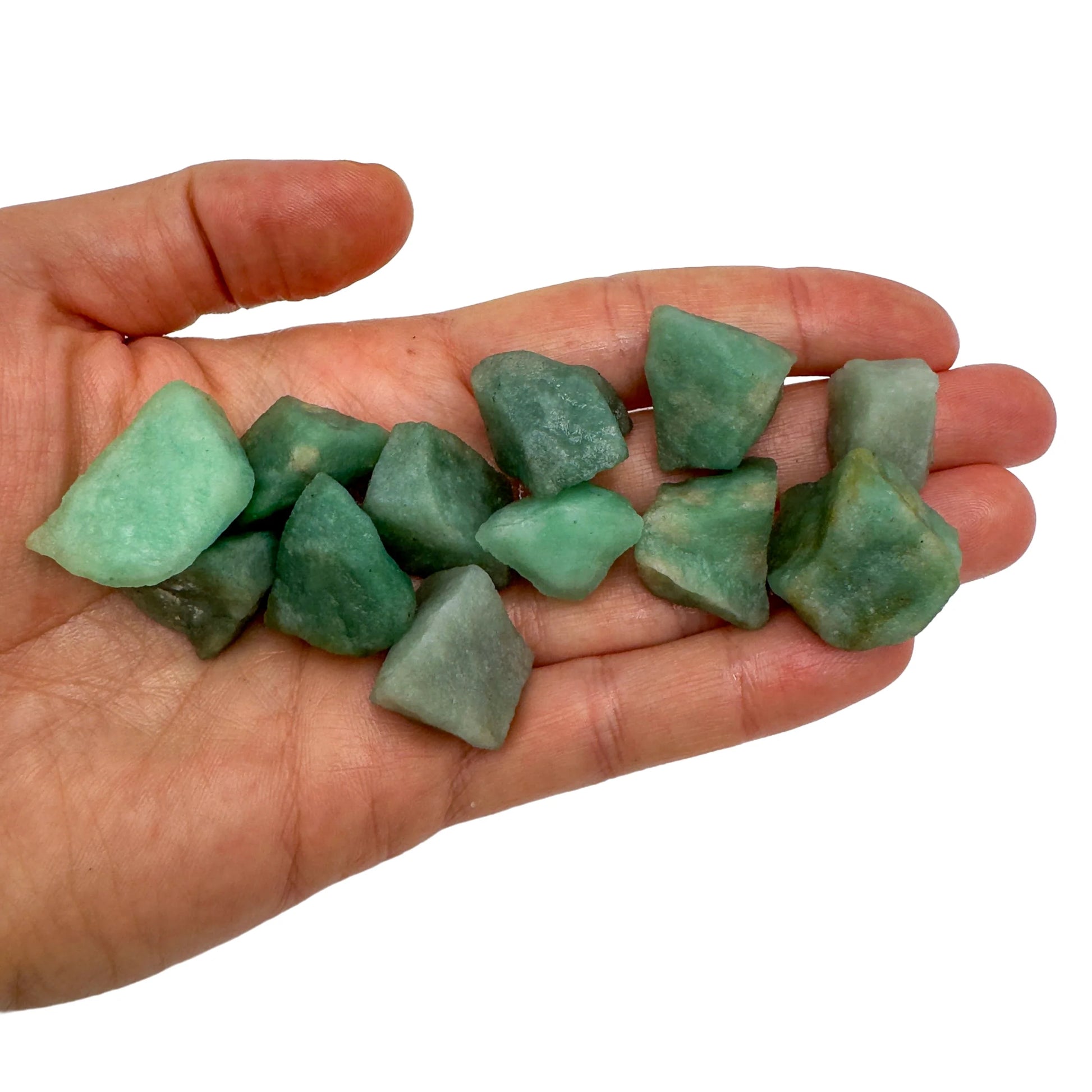 Hand holding small green aventurine raw stones 5-10 grams Brazil scale reference