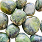 Texture-level view of Jade tumbled stone, showing earthy tone, linked to Luck and Abundance.